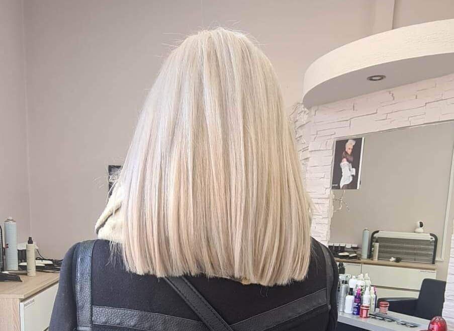 Jasny blond bob wystylizowany w Studio Fryzur Maja, w tle wnętrze salonu z lustrem